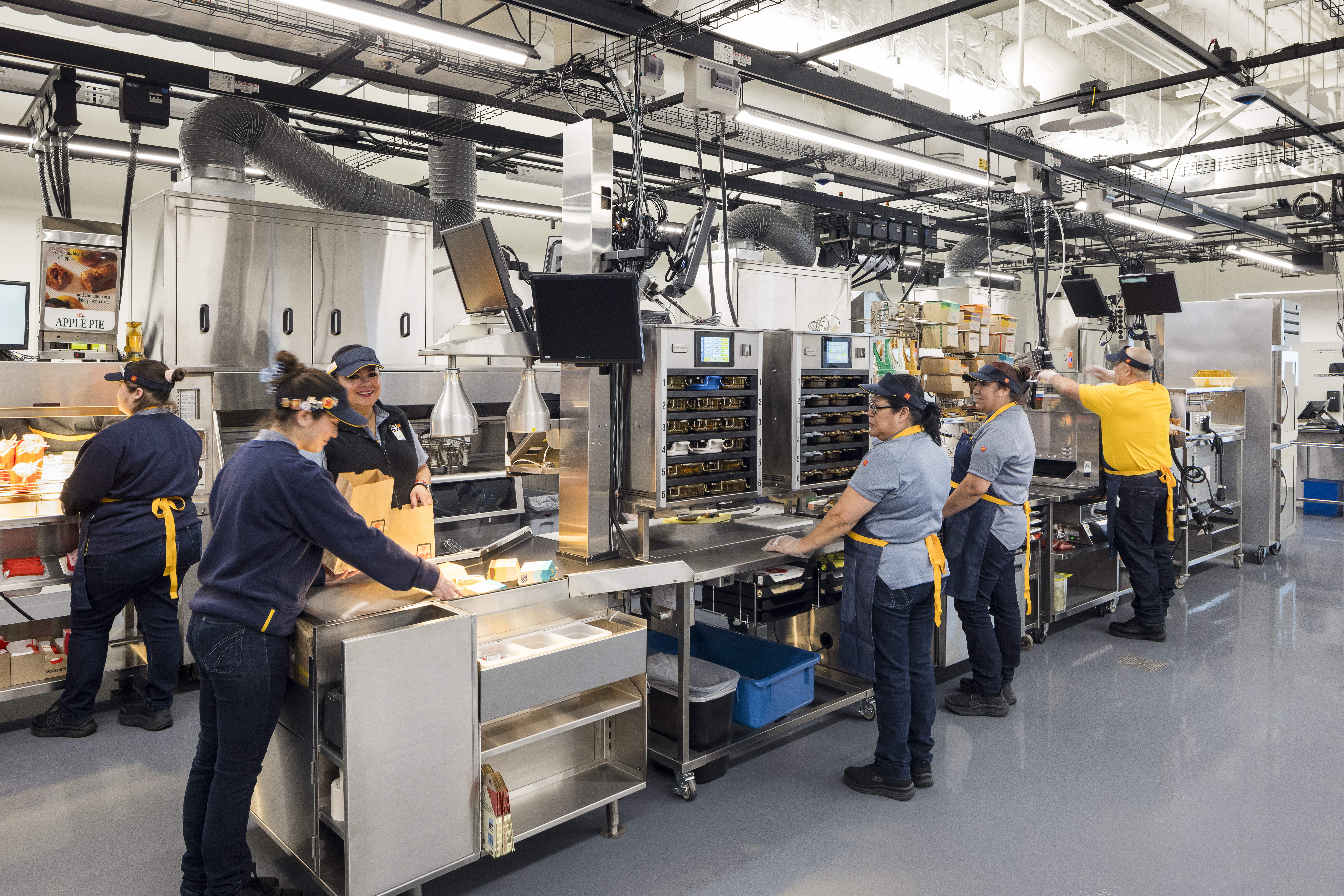 McDonald’s Crew members at work using kitchen equipment inside the fully customizable restaurant floor 