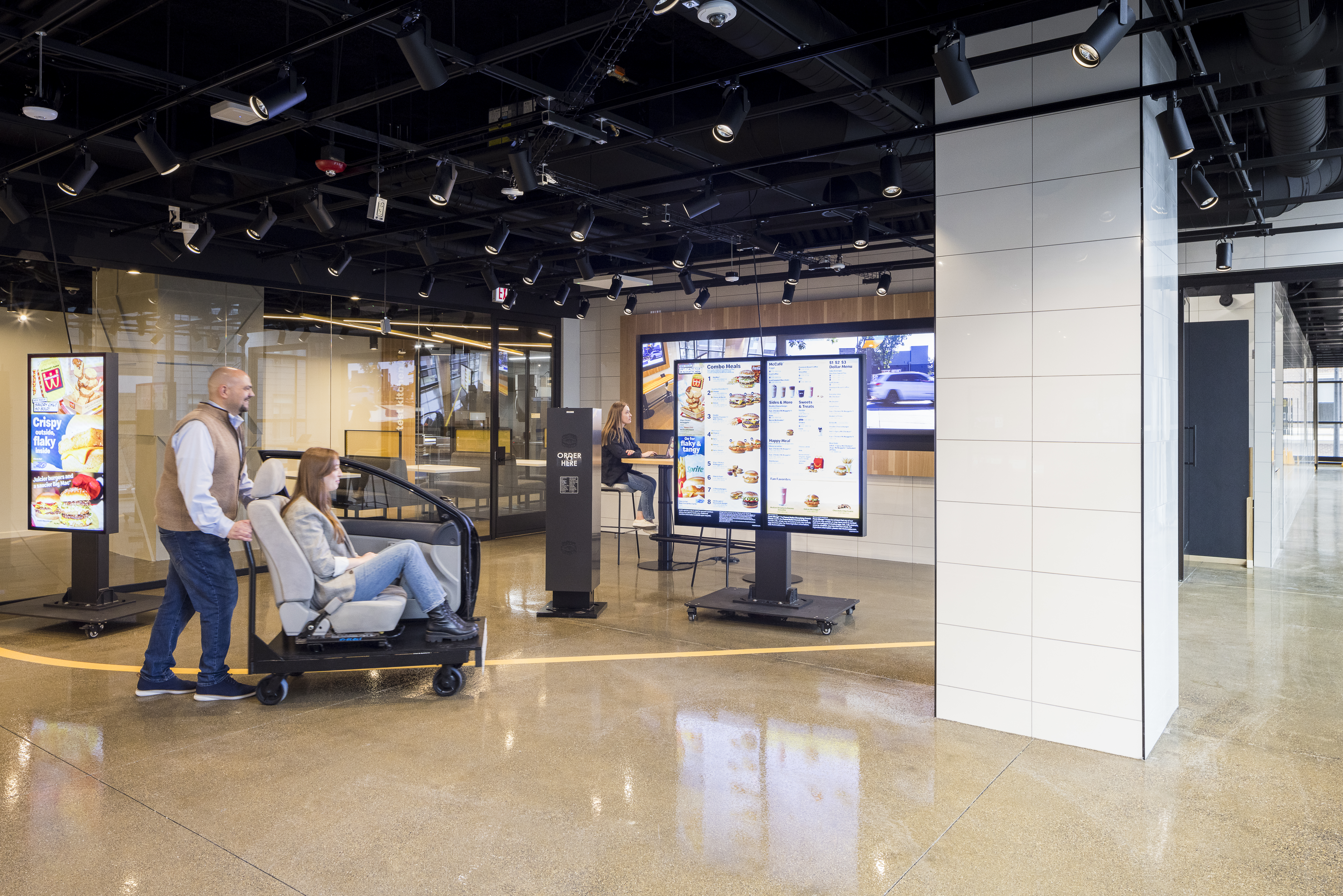 Team members using the drive-thru simulator in Speedee Labs