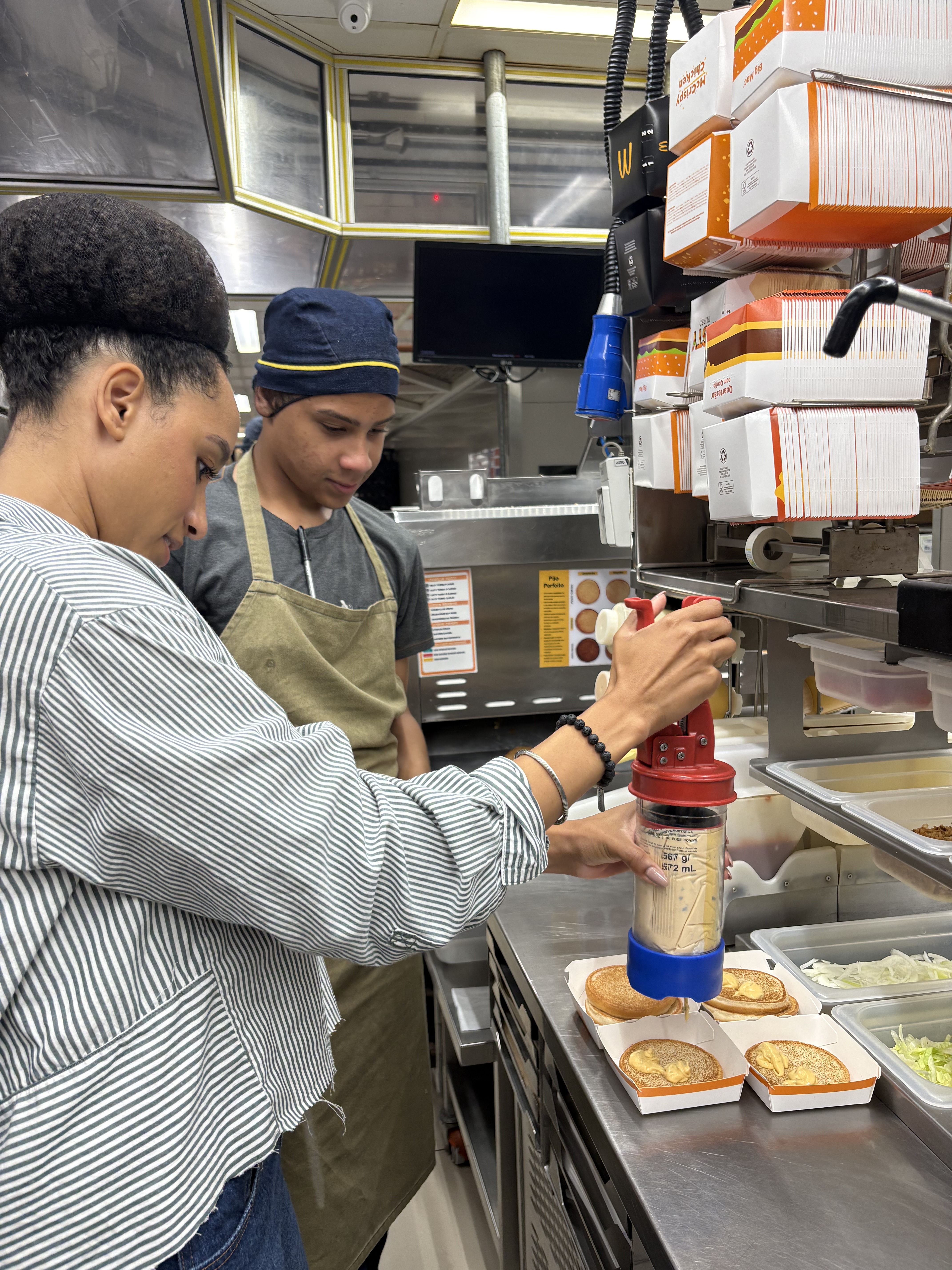 McDonald’s Latin America Crew member and Open Doors program guest preparing a burger 