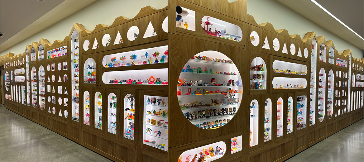 McDonald’s corporate headquarters wall of past Happy Meal® toys showcased behind glass in display cases of all shapes and sizes