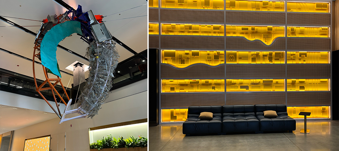 A hanging oval-shaped sculpture hanging in MHQ’s lobby made of kitchen appliances like fry baskets and a glowing yellow wall in the lobby