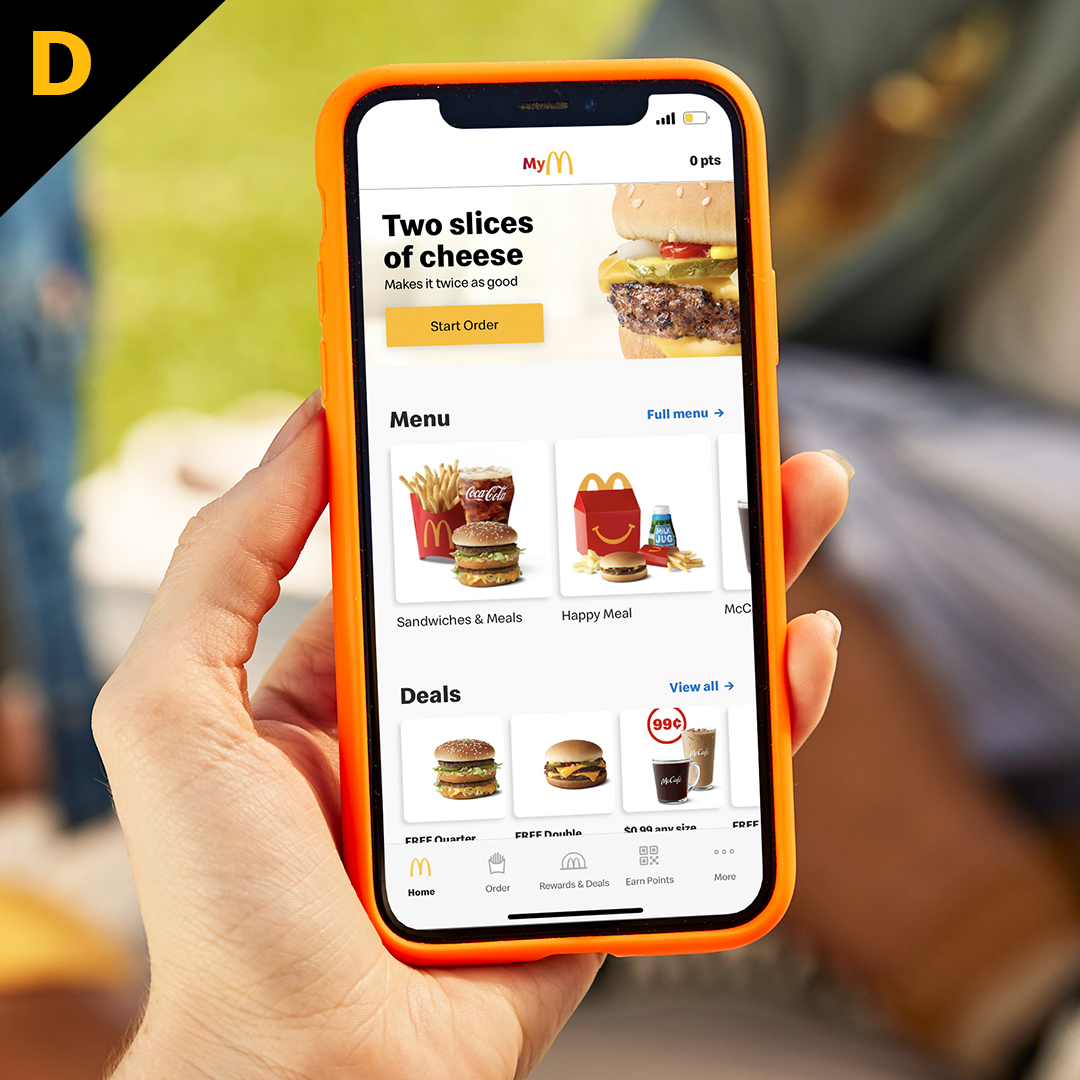 Customer holidng cell phone with McDonald's app on screen
