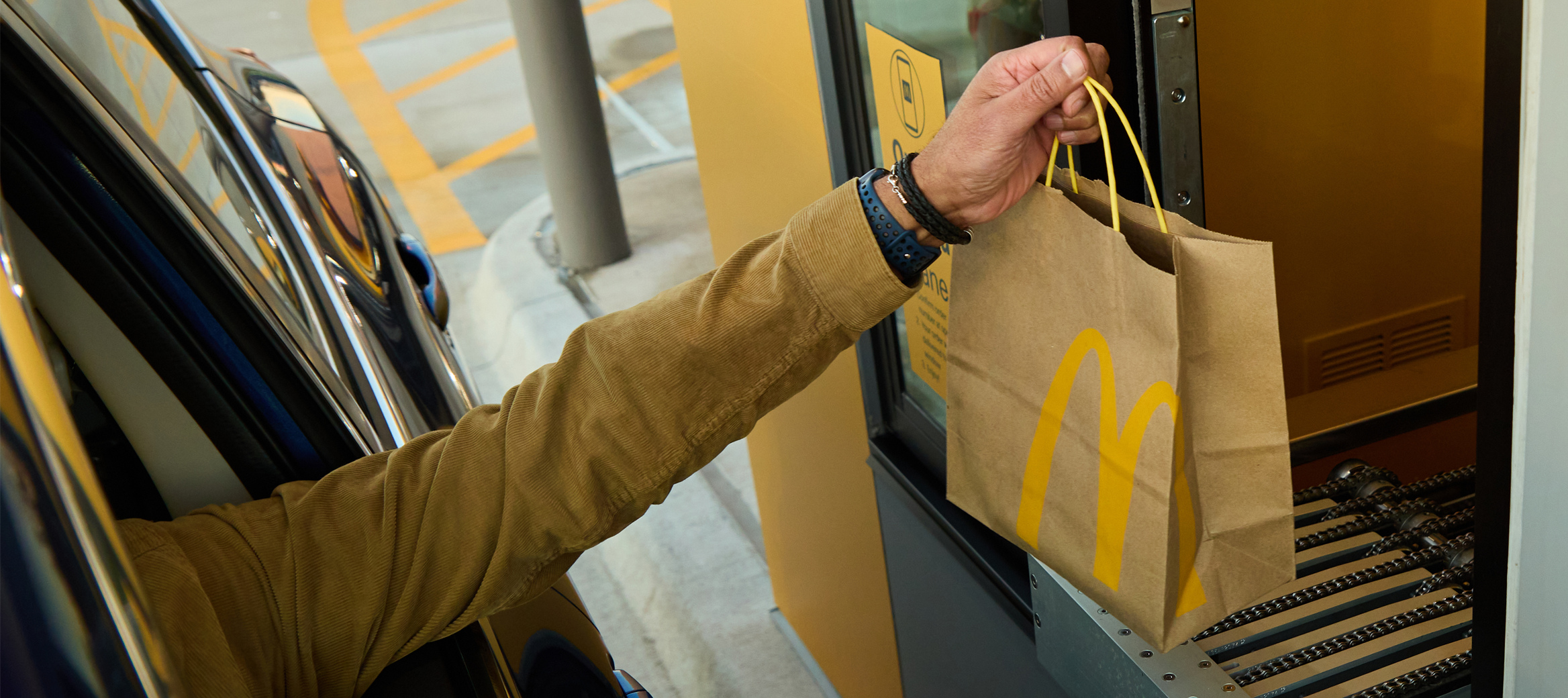 customer in car grabbing food from order ahead window