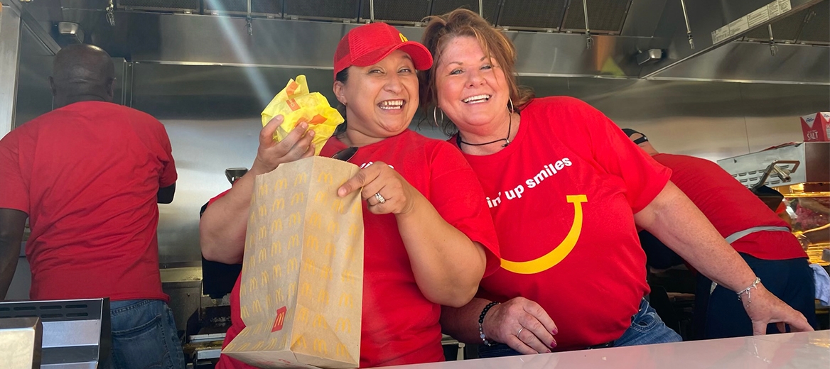 Smiling crew members serving food