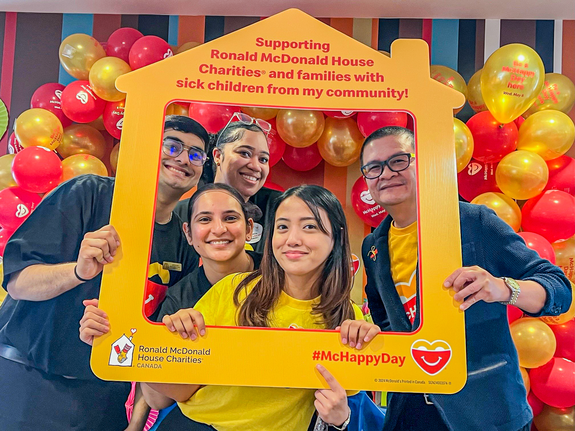 Excited participants of McDonald’s Canada’s McHappy Day smile for a photo with a Ronald McDonald House Charities frame prop Excited participants of McDonald’s Canada’s McHappy Day smile for a photo with a Ronald McDonald House Charities frame prop