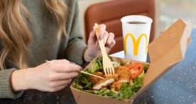 A person eating a McDonald’s meal, drink on the side
